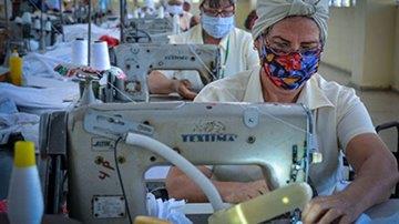 Costureras en el taller confeccionan los uniformes en máquinas de coser